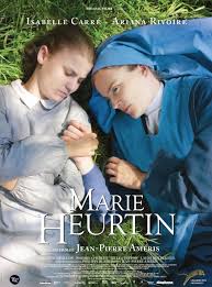 Affiche du film Marie HEURTIN. On y voit les deux actrices qui jouent le rôle de Marie et de Soeur Marguerite allongées dans l'herbe et qui se tiennent par la main.