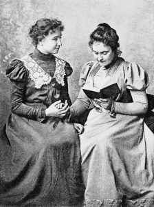 Photo d'Helen KELLER et Ann SULLIVAN. Ann lit un livre à Helen en dactylologie tactile